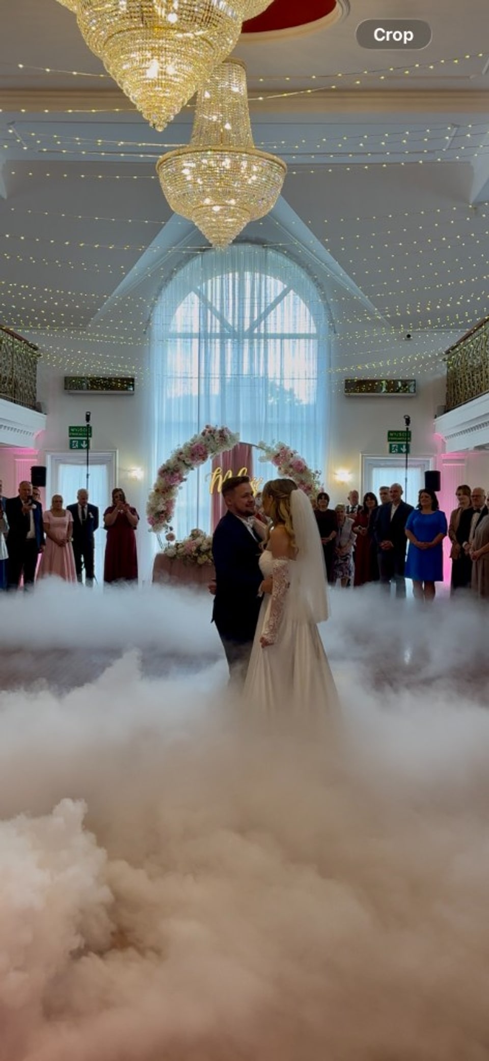 Pierwszy taniec w ciężkim dymie — Para Młoda na parkiecie w eleganckiej sali weselnej